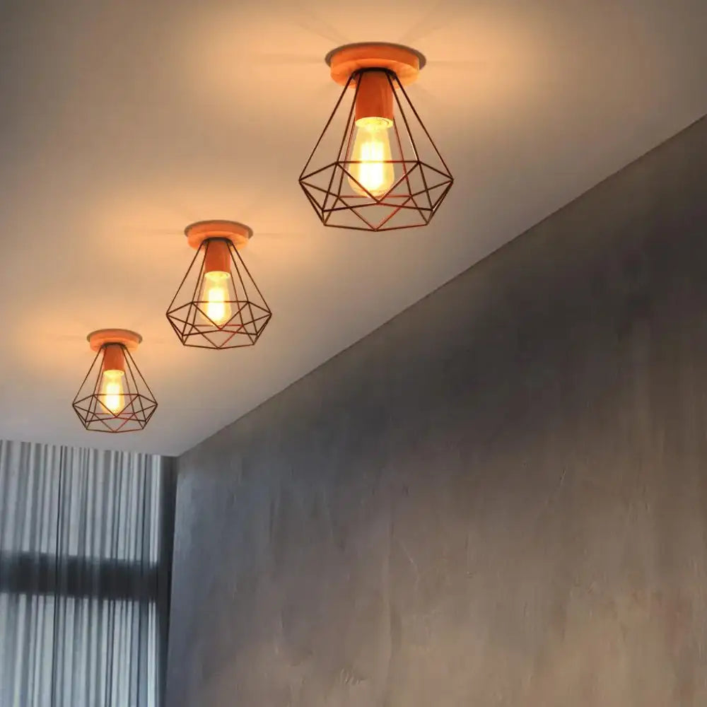 Three warm-toned geometric wire cage ceiling lights with wooden bases for decorbites industrial vintage ceiling decor