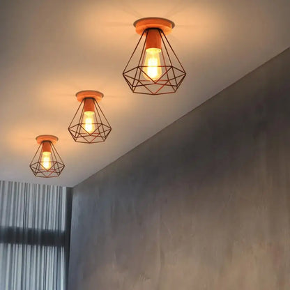 Three warm-toned geometric wire cage ceiling lights with wooden bases for decorbites industrial vintage ceiling decor