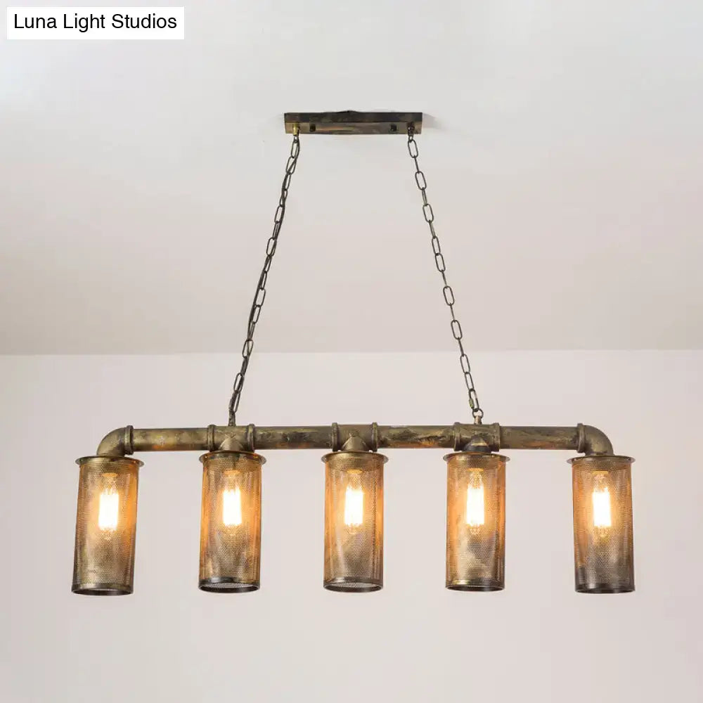 Industrial-style wrought iron pendant light with five amber glass cylinders and 110v-120v bulb base mounted on rustic brass frame