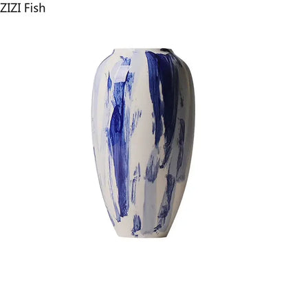 A sleek white ceramic vase with bold abstract blue ink style brushstrokes for living room decor