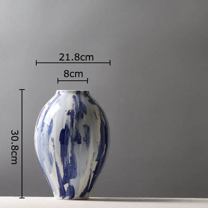 A sleek hand-painted ceramic vase with bold blue ink style brushstroke patterns on a white base for living room decor