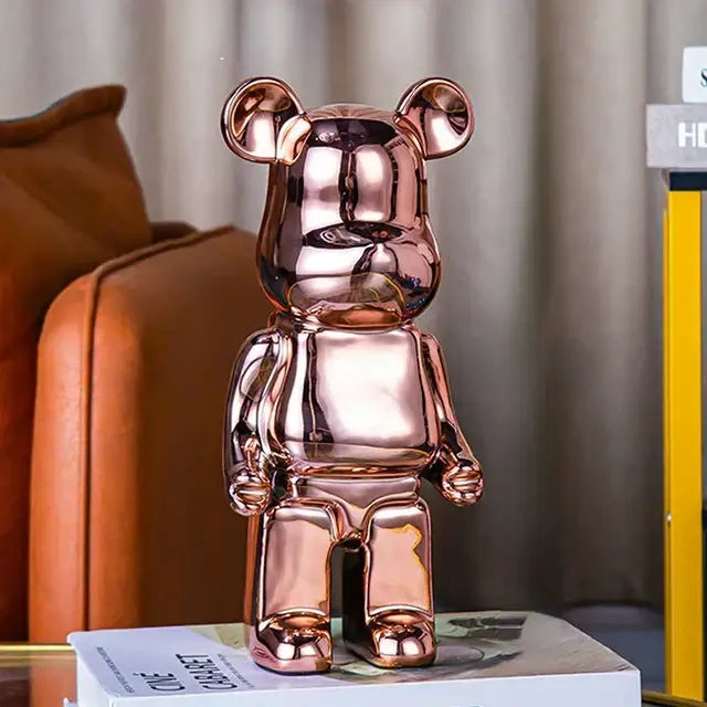 Rose gold metallic bearbrick piggy bank with glossy reflective surface and rounded ears for cabinet sculpture decor