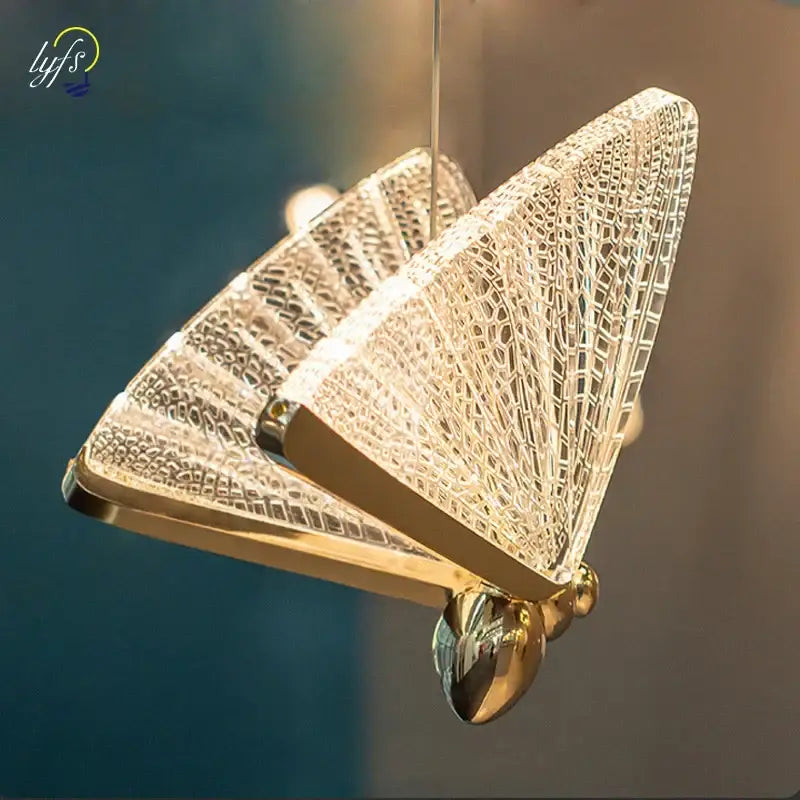Gold-toned butterfly pendant lights with intricate crystal mesh wings and polished metallic body for living room