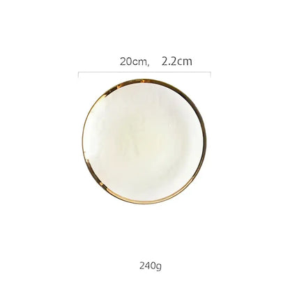 A round white ceramic plate with a thin gold rim for use with a glass salad bowl on the dining room table