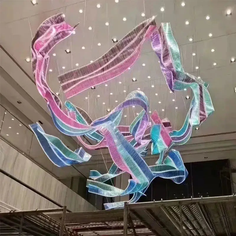 A vibrant iridescent ribbon chandelier pendant light in pink blue and teal for stylish living room lighting