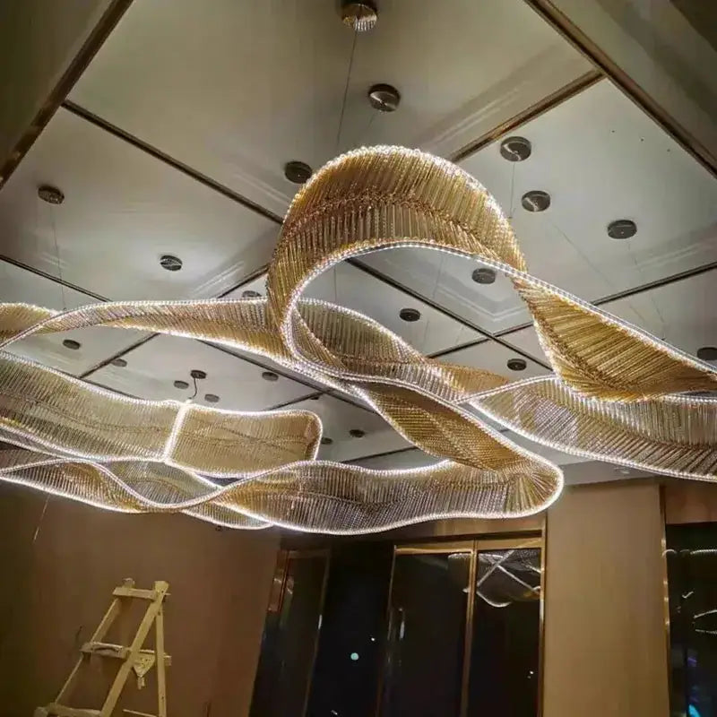 A modern gold-toned chandelier pendant with flowing crystal ribbons and embedded led lighting for living room lighting