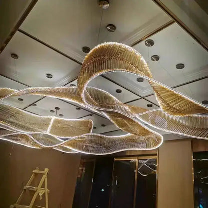 A modern gold-toned chandelier pendant with flowing crystal ribbons and embedded led lighting for living room lighting
