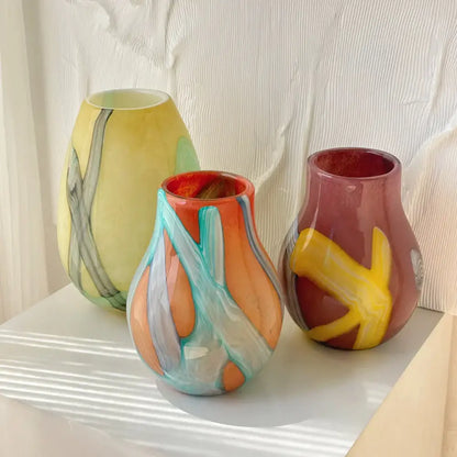 Three colorful hand-blown glass vases with irregular geometric graffiti patterns in vibrant hues for living room decor