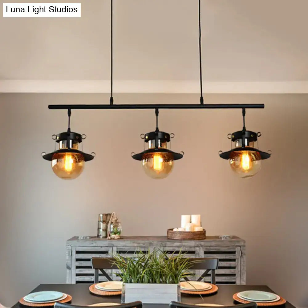 Decorbites 3-light linear hanging island pendant with black metal frame and flared shade amber glass globes