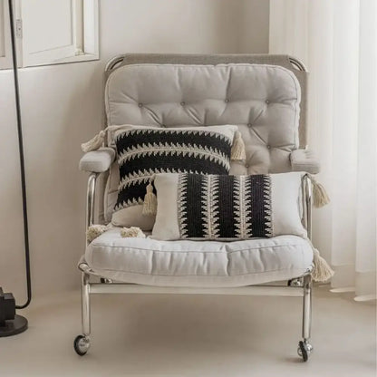A sleek modern armchair with tufted beige upholstery and chrome legs complements decorbites jacquard crochet pillow covers