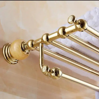 Gold-toned bathroom towel rack with ornate spherical finials and polished brass finish in jade gold bathroom accessories