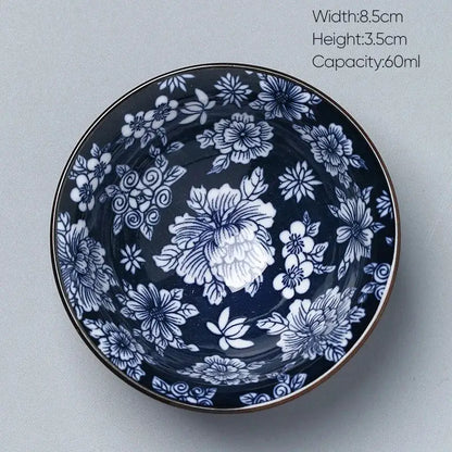A navy blue ceramic kung fu tea cup with intricate white floral patterns and a metallic rim by decorbites ceramic
