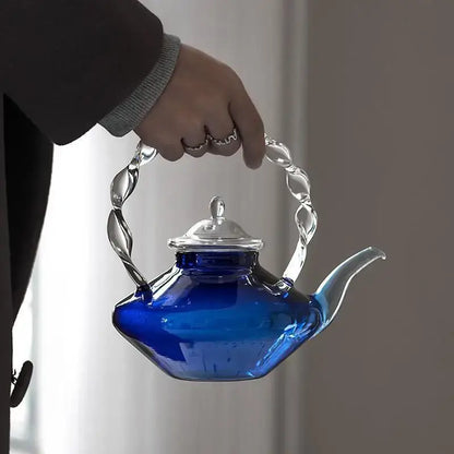 A vibrant cobalt blue glass teapot with twisted silver-toned metal handle and lid ideal for decorbites blue glass decor