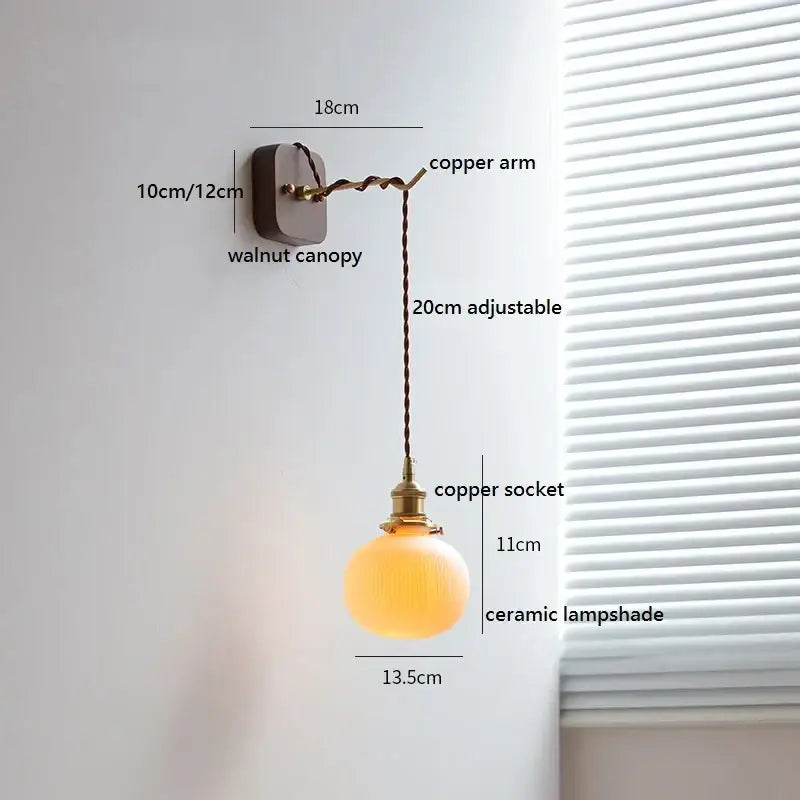 Warm-toned ceramic led wall light with brass socket and adjustable copper arm mounted on walnut canopy decorbites ceramic led