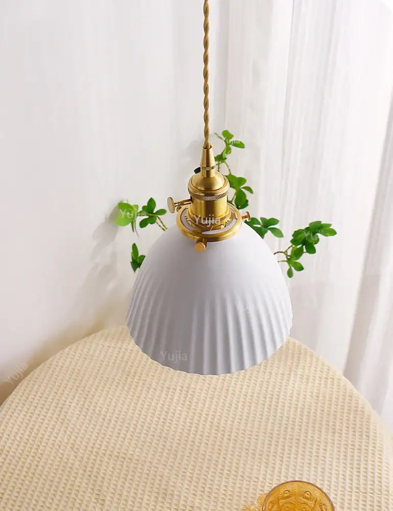 White ribbed ceramic pendant light with brass fixture and twisted cord for kitchen and dining room use