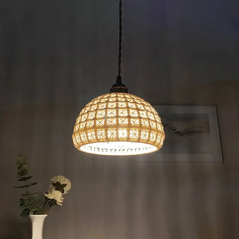 A warm glowing ceramic pendant light with a woven rattan shade and geometric lattice for kitchen or dining room
