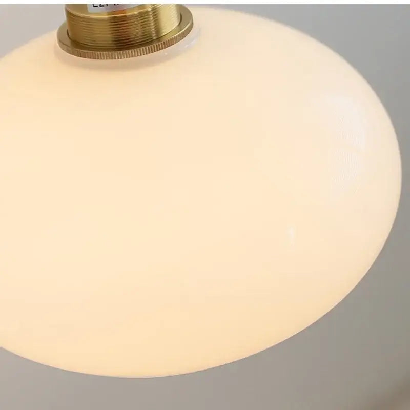 Cream-colored opal glass wall sconce with brass-finished metal fixture decorbites japanese style led bedroom light