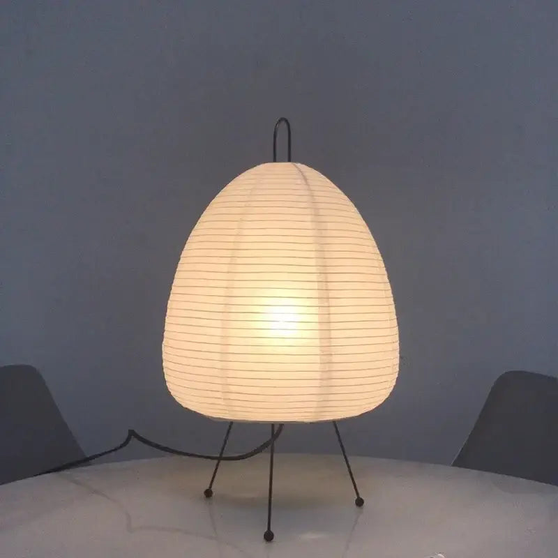 A warm white japanese style rice paper desk lamp with black metal tripod base ideal for bedroom lighting decorbites japanese style