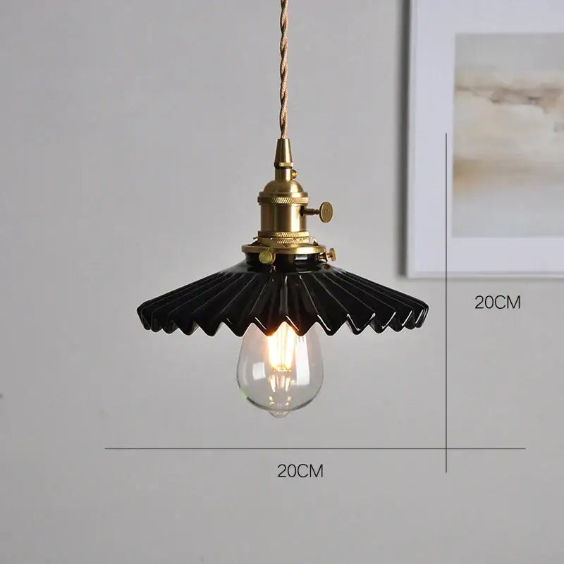 Black ceramic pendant light with brass socket and twisted cord paired with polished copper finish kitchen lighting