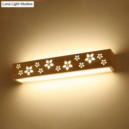 Japanese wooden floral wall lamp with warm tones and delicate cutouts designed as a bedroom led sconce with shelf