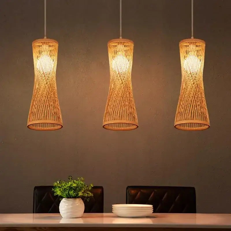 Three warm-toned Japanese woven bamboo pendant lights with natural finish hanging in a modern dining room space