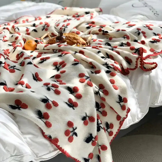 Cream-colored kids wool blanket with red and black decorbites 3d cherry appliqués and matching red pom-pom trim