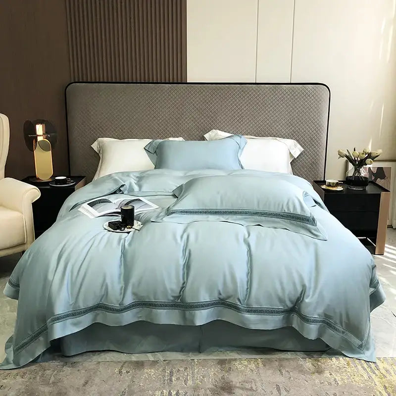 Light blue satin bedding set with dark teal embroidered trim made from decorbites eucalyptus lyocell luxury fabric
