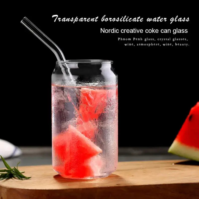Large transparent borosilicate shape beer glass cup filled with ice and red fruit slices with metal straw for dining room