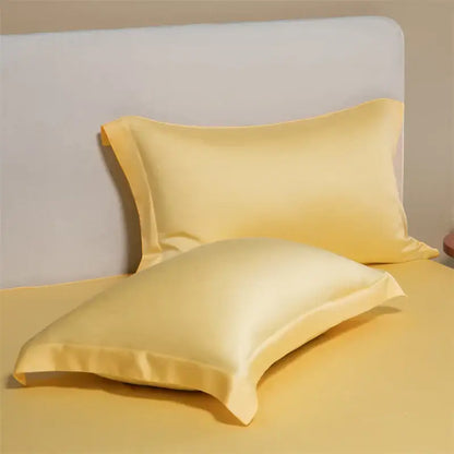 Pair of pale yellow satin egyptian cotton pillowcases with a smooth glossy finish in a cotton pillowcase set