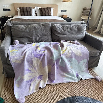A soft lavender and cream floral decorbites cozy knit blanket with tassels perfect as a living room throw