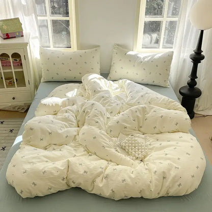 Cream-colored quilt with delicate gray bows from lavender floral textured cotton bedding set for bedroom use