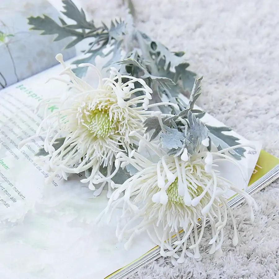 White artificial chrysanthemum flowers with silvery-gray foliage on a lavender and orange artificial crab claw branch decorbites artificial crab for wedding decor