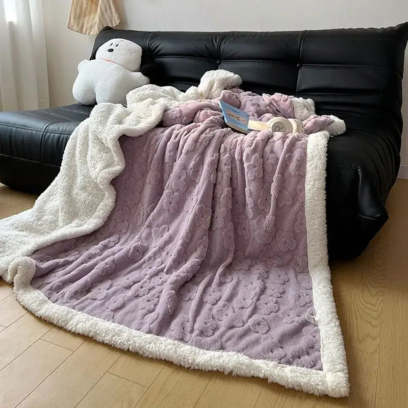 A lavender and white cozy lamb wool flower throw blanket with soft textured floral pattern and sherpa trim for bedroom bedding