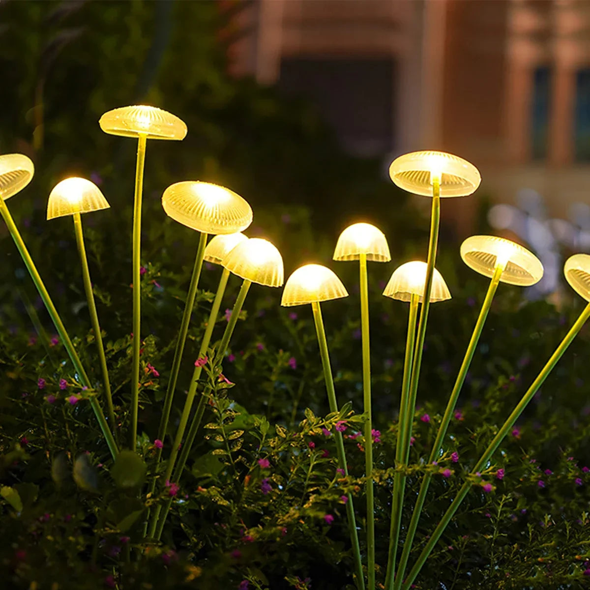 Glowing yellow LED solar jellyfish mushroom lamp with slender green stems for outdoor garden and lawn decoration lighting