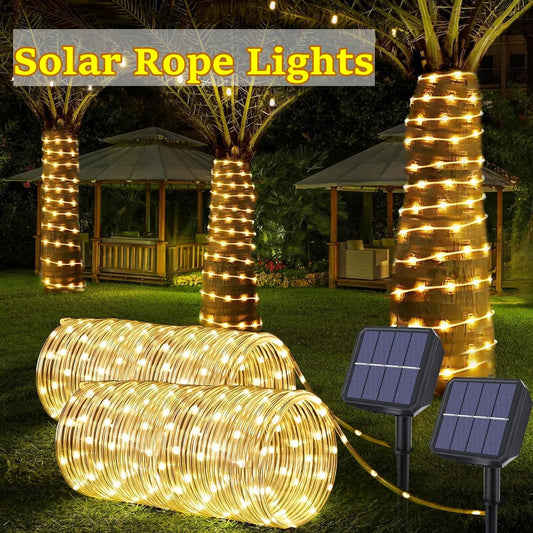 Warm white led solar strip rope lights coiled on grass with two black solar panels for outdoor garden decor