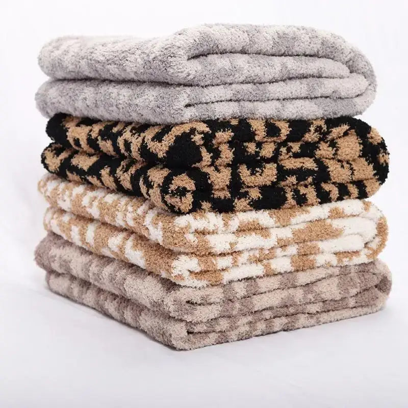 Stack of plush fleece blankets in neutral tones and black-and-tan leopard print decorbites leopard print throw