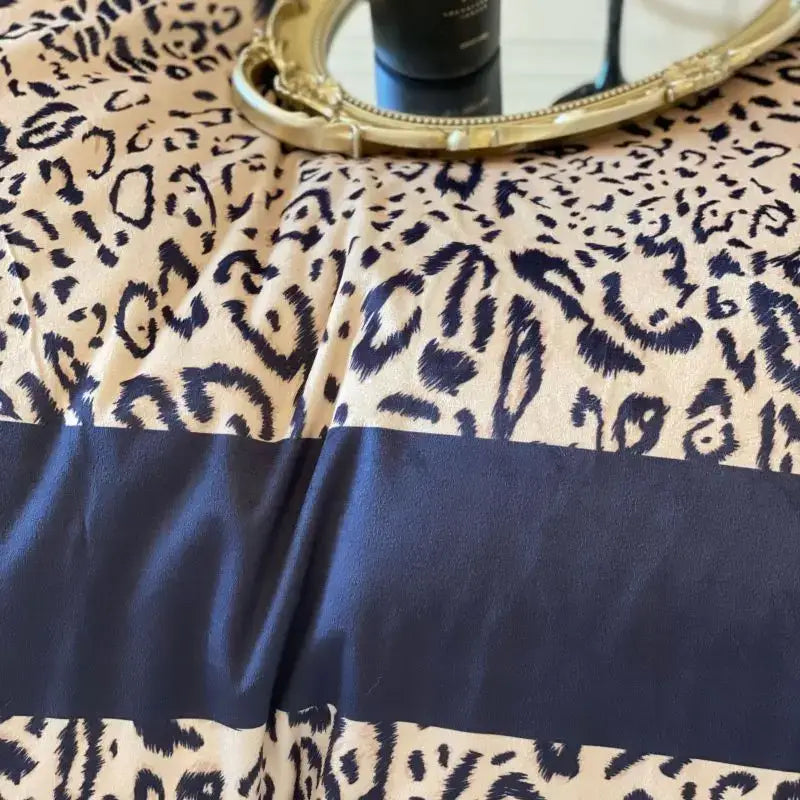 Cream-colored leopard print velvet bedding set with bold navy blue pattern and solid navy band for decorbites decor