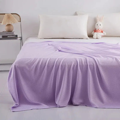 A soft lavender bamboo fiber summer quilt with textured woven pattern draped over the bed decorbites bamboo fiber