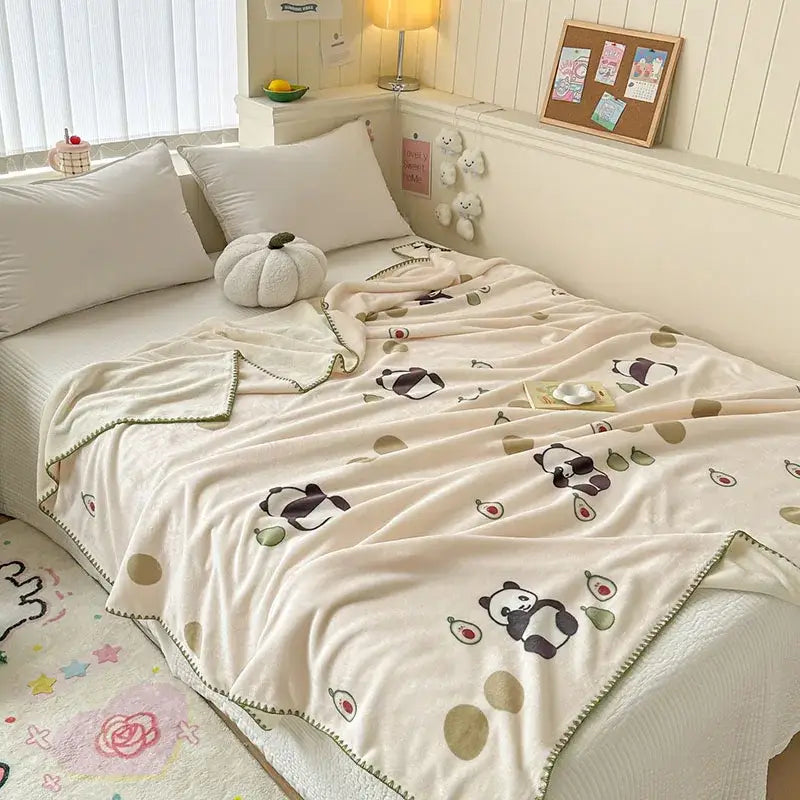 Cream-colored milk velvet blanket with playful panda and avocado designs and soft green border from decorbites cozy milk collection