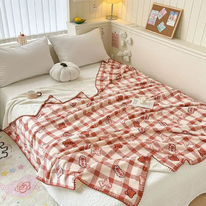 A cozy red and cream checkered milk velvet blanket featuring playful bear patterns and pom-pom trim by decorbites cozy milk
