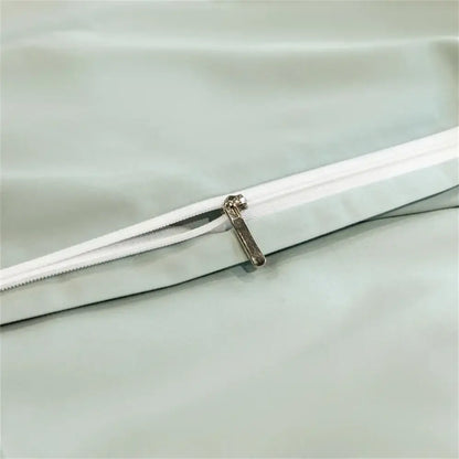Silver zipper with metallic pull tab on light green fabric of light blue embroidered egyptian cotton bedding set