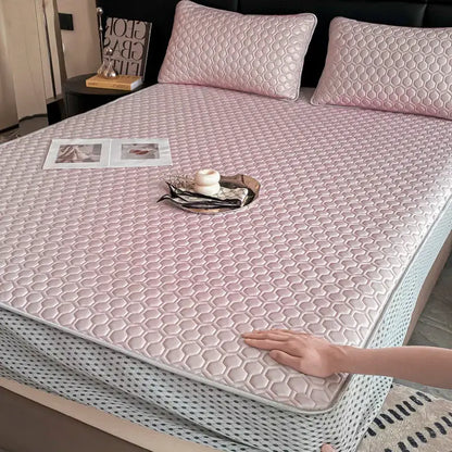 Pink hexagonal quilted mattress pad with light gray border as part of a light blue ice silk cooling bed mat set