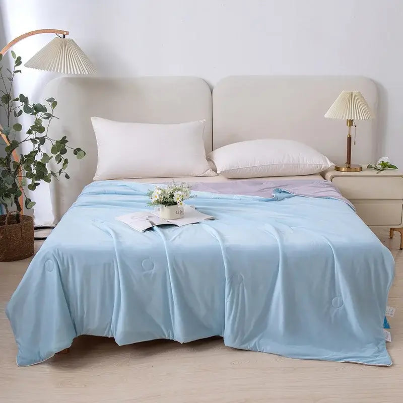 Light blue soft textured air conditioning quilt with subtle circular stitching for summer bedroom use