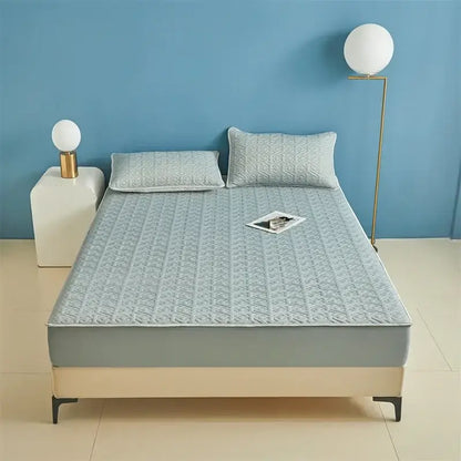 Light blue quilted latex fitted sheet set bed pad with subtle geometric pattern and stitched edges for bedroom use