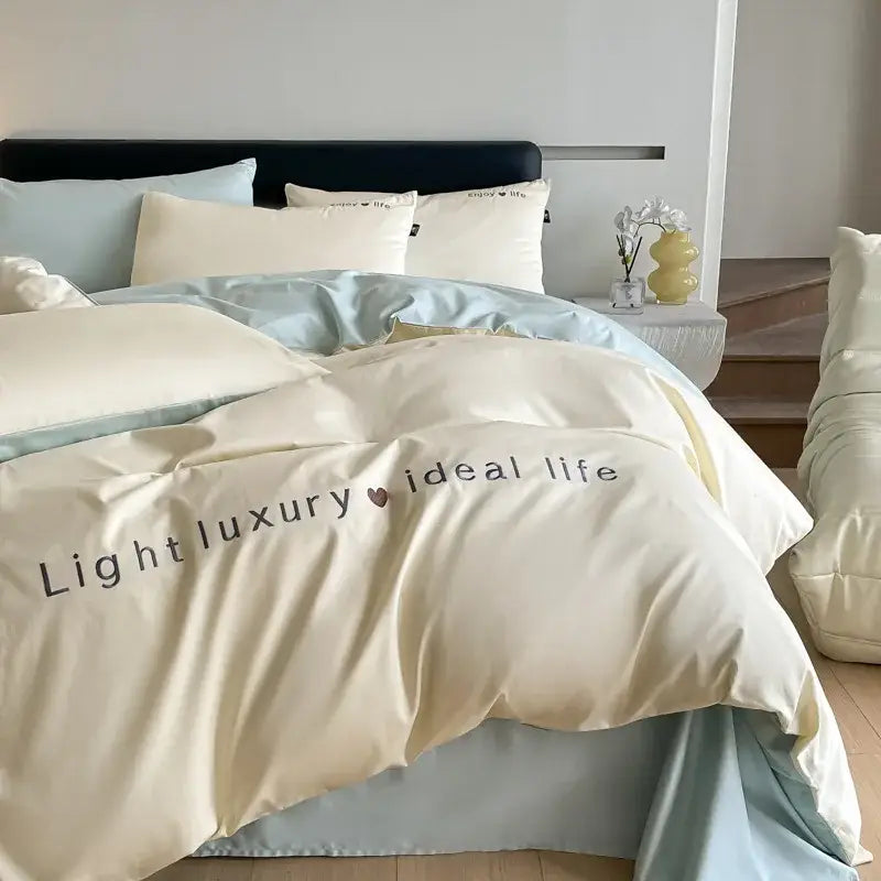 Cream-colored satin embroidery duvet cover with subtle sheen featuring light luxury ideal life text in decorbites bedding set