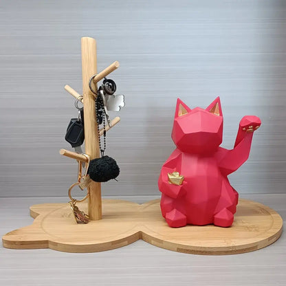 Light brown wooden key rack holder with a vibrant red geometrically designed lucky cat figurine and gold accents