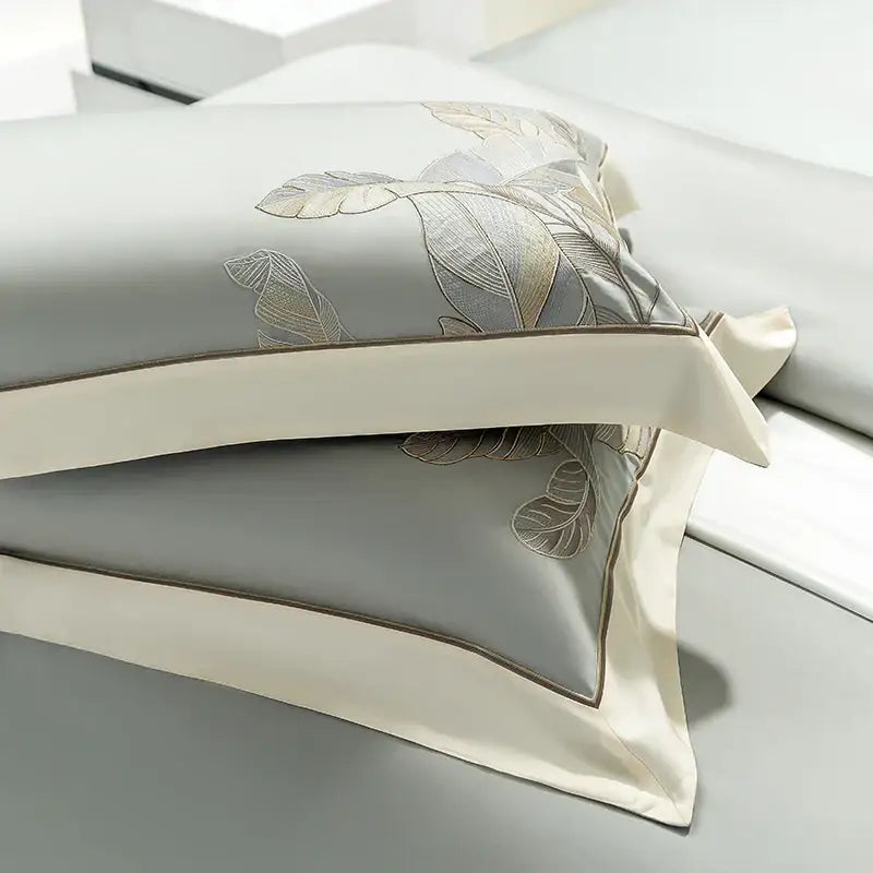 Light gray eucalyptus lyocell soft bedding set with gray satin pillowcases featuring gold and silver leaf embroidery edges