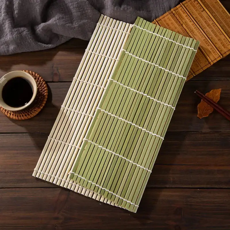 Two bamboo sushi rolling mats in natural beige and light green with white bindings in a rolling mat set for diy kitchen use