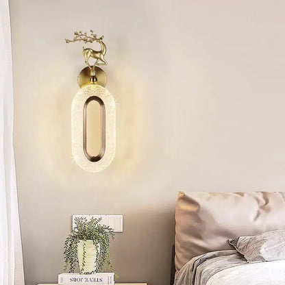 Gold-toned deer-themed wall lamp with oval textured glass shade and metallic accent for light luxury modern decorbites bedroom