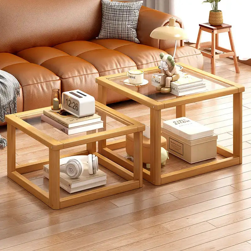 Light wood two tier glass coffee table set with clear tops and open shelving for living room storage and display